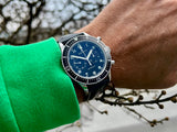Zenith Cronometro CP 2 lim 1000 am Handgelenk vor einem Strauch